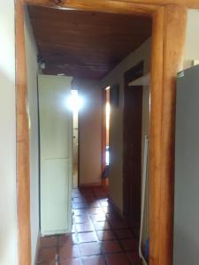 un pasillo con una habitación con puerta y luz en Zahra Depto en Villa Gesell