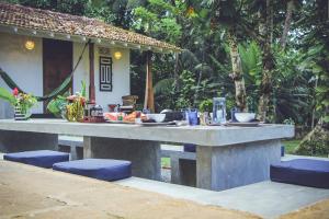 a large concrete table with blue chairs in front of a house at Templeberg in Galle