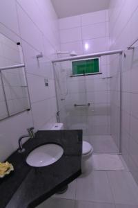 a bathroom with a sink and a shower and a toilet at Pousada Paraíso dos Lençóis in Barreirinhas