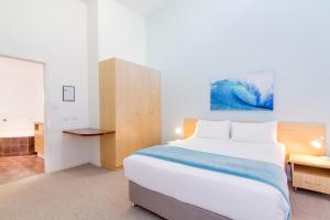1 dormitorio con 1 cama grande y escritorio en Angourie Resort, en Yamba