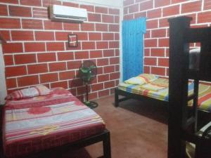 a room with two beds and a brick wall at Rancho Mar in Rincón