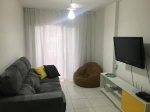 sala de estar con sofá y TV de pantalla plana en Balneário Camboriú lindo apto proximo Mar, en Balneário Camboriú