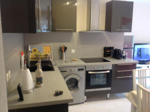 uma cozinha com uma máquina de lavar roupa e um fogão em Rez de Villa Pébrier em Fréjus