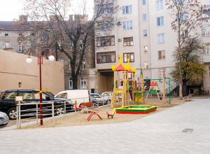 un parco giochi di fronte a un grande edificio di Travel station apartment a Ivano-Frankivsʼk