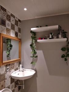 a bathroom with a sink and plants on the wall at Shofiya Guesthouse Solo in Solo