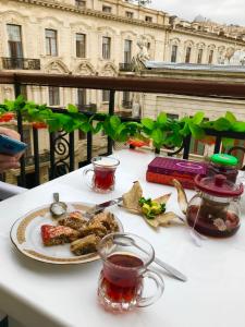 a white table with a plate of food on it at Fountain Square-Balconies in Old Town in Baku