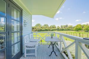 a porch with a table and chairs and a view at Bycroft Lodge in Karaka
