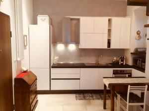 una cocina con armarios blancos y fregadero en Mini Appartamento Centro Storico, en Pescocostanzo