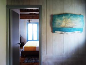 a bedroom with a painting of a sailboat on the wall at Villa Antonia in Almirida