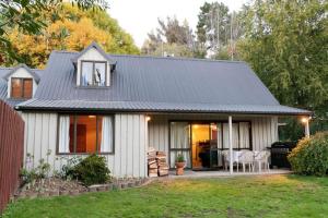 a house with a gray roof and a yard at Lazy Daze in Wanaka
