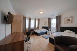 Habitación de hotel con 2 camas y escritorio en Pension Donau, en Hannover