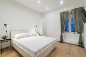ein weißes Schlafzimmer mit einem weißen Bett und einem Fenster in der Unterkunft Studios & Apartments Porto in Zadar