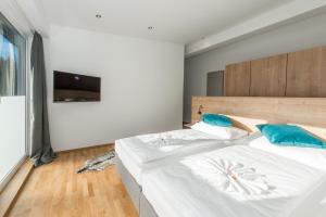 a bedroom with a large white bed with blue pillows at Deluxe Apartment Berglust in Schladming