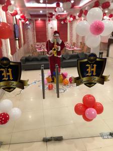 a man standing in a room with a bunch of balloons at Hotel Rivera Palace in Varanasi