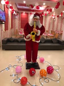 a man dressed as santa claus playing a saxophone at Hotel Rivera Palace in Varanasi