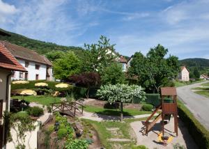 uma vista para um jardim a partir de uma casa em Hotel Restaurant Auberge Metzger em Natzwiller