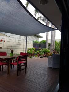 une terrasse avec une table et des chaises sous un parasol dans l'établissement Papamoa Retreat, à Tauranga
