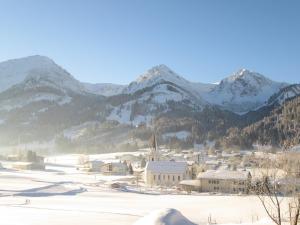 a town in the snow with mountains in the background at Haus Romantika in Schattwald