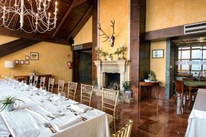 a dining room with a long table and a fireplace at Hotel Spa Milagros Golf in Mogro