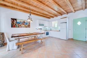 - une cuisine et une salle à manger avec une table et un banc en bois dans l'établissement Naoussa Bay Villas, à Náoussa