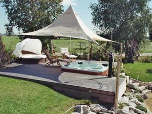 een terras met een hot tub en een tent bij Riedblick in Bad Buchau