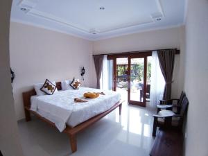 1 dormitorio con 1 cama blanca grande en una habitación en Muka House, en Ubud