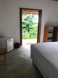 カライーバにあるCasa Mangabaのベッドとガラスの引き戸のある寝室
