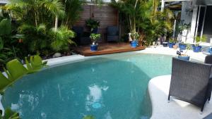 a swimming pool in a yard with potted plants at Oasis on Nautilus in Port Douglas