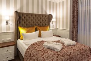 a bedroom with a bed with two towels on it at Europa Hotel Kühlungsborn in Kühlungsborn