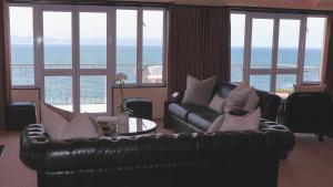 a living room with a leather couch and a table at Heaven's Window in Hermanus