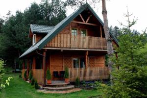 a log cabin with a porch and stairs leading to it at Sarzynówka in Krasnobród