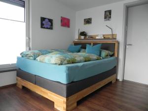 ein Schlafzimmer mit einem Bett mit einem Holzrahmen in der Unterkunft Apartment Schwäbisch Hall in Schwäbisch Hall