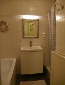 a bathroom with a sink and a tub and a mirror at d'AldeSkoalle in Molkwerum