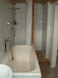 a bathroom with a white tub and a sink at Schloßblick in Lohmen