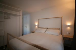 a bedroom with a white bed with two pillows at White Edelweiss in Livigno