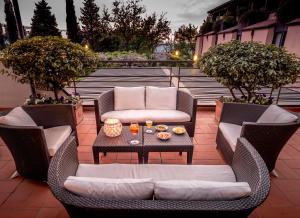 un patio con 2 sedie in vimini e un tavolo di BV Grand Hotel Assisi ad Assisi