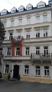 a large white building with windows and a balcony at Rezidence Sadová in Karlovy Vary