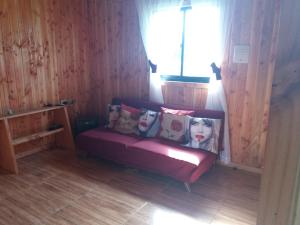 a couch with pillows on it in a room at Arquería Patagonia Lodge in Puerto Varas