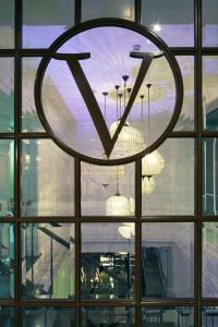 a large chandelier with the letter v in a window at Vania Rooms Hotel in Vladimir