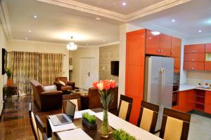 a kitchen and living room with a table and a refrigerator at St Georges Height in Accra