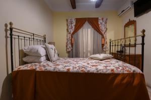 a bedroom with a bed with pillows and a window at Maria Giovanna Guest House in Marsalforn