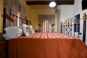 a bedroom with a bed with an orange bedspread at Maria Giovanna Guest House in Marsalforn