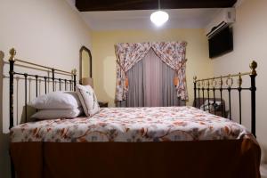 a bedroom with a bed with a bedspread and a window at Maria Giovanna Guest House in Marsalforn