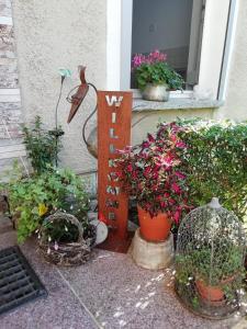 Ferienwohnung Zur Alten Eiche في Frohburg: مجموعة من النباتات الفخارية وعلامة على الشرفة