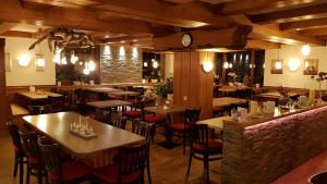 a restaurant with tables and chairs and a clock at Gasthof Küssaburg in Küssaberg