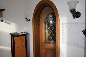 una puerta de madera con una ventana de cristal junto a un tocador en FEWO-Horgau, en Horgau
