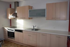 a kitchen with a sink and a stove and cabinets at FEWO-Horgau in Horgau