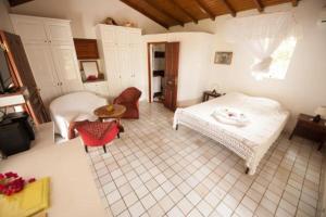 Un dormitorio con 2 camas y una mesa en una habitación en Kristal'Inn Cottage Caraibe, en Capesterre