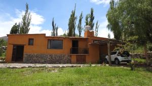 a house with a car parked in front of it at Pircas del Abuelo in Tilcara