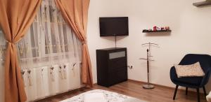 ein Wohnzimmer mit einem TV und einem Fenster in der Unterkunft Central Apartment DumDix Brasov in Braşov